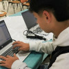 Foto que muestra a un hombre escribiendo en un computador 