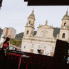 Imagen de una mujer dj tocando una consola al frente de la iglesia en la Plaza de Bolivar