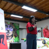 Foto de una mujer hablando por micrófono 