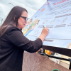 Foto de una mujer firmando una pancarta 
