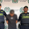 Hombre capturado por homicidio en medio de dos policías.