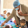 Imagen de una mujer atendiendo a niños y niñas en un comedor