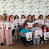 Foto de un grupo de mujeres posando con una bolsa blanca 