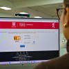 Mujer mirando a un computador, en cuya pantalla se ve la plataforma LICO.