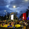 Personas reunidas en parque de Bogotá durante transmisión pública de partido de la Selección Colombia en pantallas gigantes