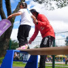 Niña realiza ejercicio de equilibrio con acompañamiento del IDRD en parque recreativo