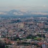 Vista panorámica de Bogotá con edificaciones extensas, montañas lejanas y cielo despejado