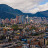 Vista panorámica de Bogotá con edificios residenciales, zona financiera y cerros orientales bajo cielo parcialmente nublado