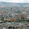 Vista panorámica de Bogotá con barrios, montañas al fondo y cielo nublado
