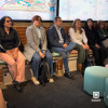 Foto que muestra personas sentadas en un salón 