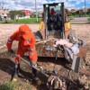 Foto que muestra trabajadores levantando residuos con una pala