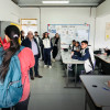 Foto que muestra un grupo de personas hablando dentro de un salón de clases