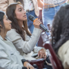 Foto de una mujer hablando por micrófono 