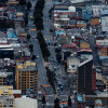 Vista aérea de avenida central de Bogotá con edificaciones densas y tráfico moderado