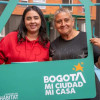 Foto que muestra dos mujeres sonriendo con un letrero que dice Bogotá mi ciudad mi casa
