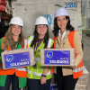 Secretaria de Ambiente, Adriana Soto, sostiene caja rotulada “AVIÓN SOLIDARIO” en bodega durante operación humanitaria