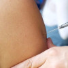 Foto que muestra una persona colocando una vacuna en un brazo 