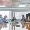 Foto que muestra personas sentadas y reunidas en una sala de juntas