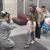 Imagen de un niño arrodillado jugando con lentes 3D mientras dos niñas y una mujer lo observan