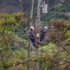 Foto que muestra dos personas con uniformes de Enel Colombia trabajando en un poste de luz