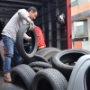Imagen de una persona cargando llantas