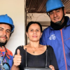 Imagen de dos operarios de etb junto a una señora sonriendo