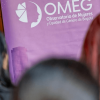 Mujeres con una pancarta del OMEG de fondo.