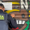 Policía pegando un aviso de suspensión temporal en un establecimiento del Siete de Agosto