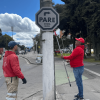 Defensores del espacio público retirando un pendón ilegal del mobiliario público.