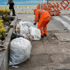 Foto que muestra personas limpiando una zona con basuras 
