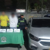 Dos de los capturados con material incautado y uno de los carros recuperados.