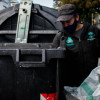 Foto que muestra una persona sacando residuos de un contenedor de basura