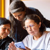 Tres mujeres mirando un celular.