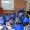 Foto que muestra estudiantes sentados en un salón de clases
