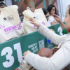 Una mujer recibiendo el kit de la carrera de la media maratón de Bogotá