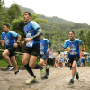 Participantes corren por el sendero empedrado de Monserrate rodeados de vegetación y público asistente.