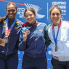 Gabriela Rueda exhibe su medalla de oro durante ceremonia de premiación de los Juegos Centroamericanos y del Caribe Santo Domingo 2026, frente al panel oficial del evento deportivo.