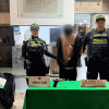 Hombre capturado, en medio de dos policías, junto a material incautado y recuperado.