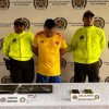 Hombre capturado en medio de dos policías, junto a elementos incautados.
