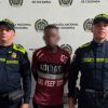 Hombre capturado, en medio de dos policías. 