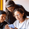 Tres mujeres mirando un celular.