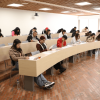 Foto que muestra personas sentadas en un salón 