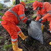 Foto que muestra dos personas con el uniforme de Aguas de Bogotá recogiendo residuos 