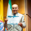 Foto de un adulto mayor con un certificado