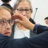 Imagen de personas mayores provandose diferentes gafas