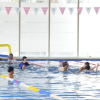 Imagen de varias personas nadando en una piscina 