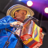 Imagen de uno de los artistas que estará en Vallenato mientras toca un acordeón.