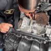 Mujer policía verificando un motor de vehículo. 