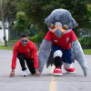 Persona y mascota institucional del IDRD realizan salida deportiva en pista durante actividad recreativa que promueve programas de deporte, actividad física y recreación para todas las edades en Bogotá.