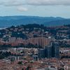 Vista panorámica de Bogotá con edificios residenciales y comerciales, cerros orientales y cielo nublado.